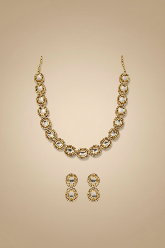 Gold necklace and earrings set on a beige background