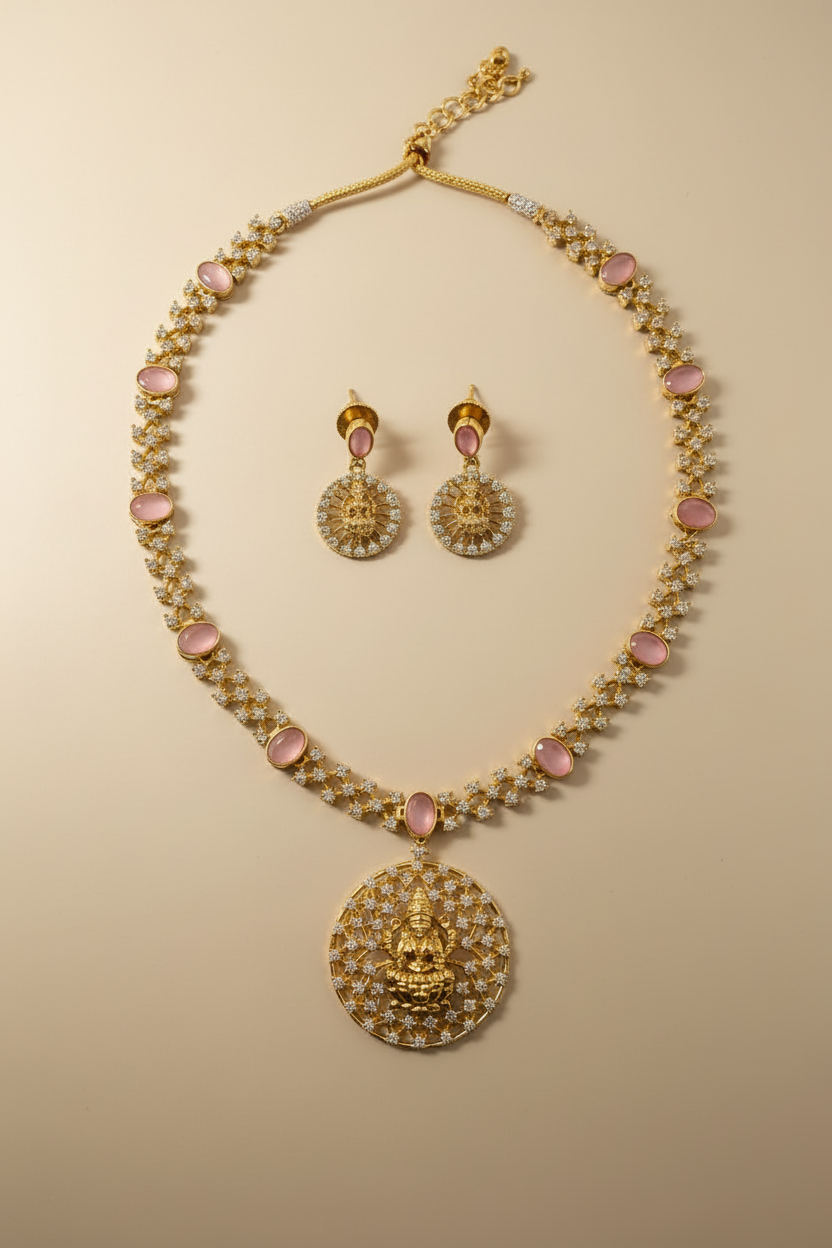 Gold necklace and earrings with pink stones on a white background