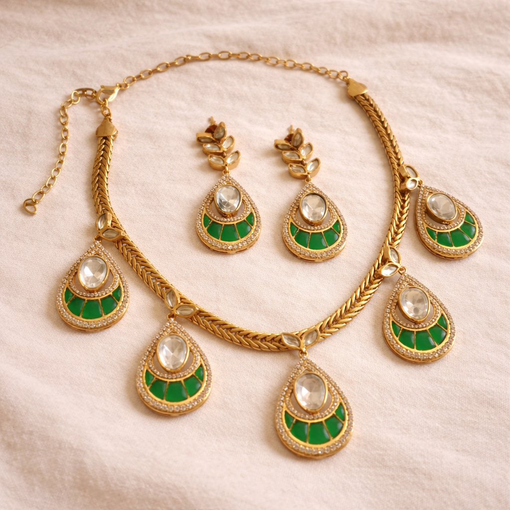 Gold necklace with green and white teardrop-shaped pendants on a beige background