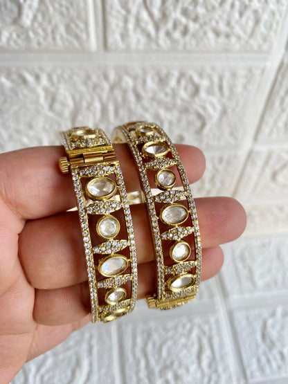 Gold and silver bangles on a hand with a textured white background