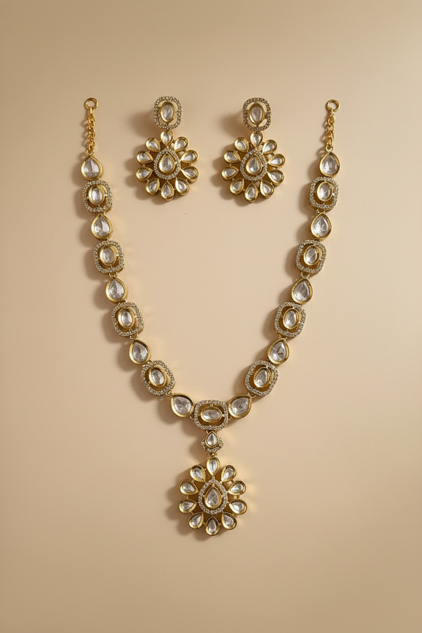 Gold necklace and earrings set on a beige background