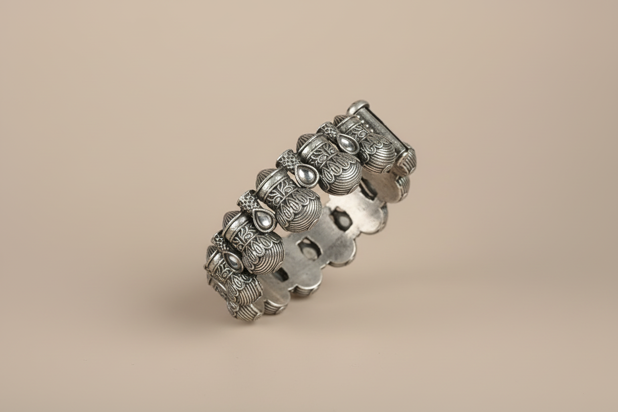 Silver bracelet with intricate designs on a beige background